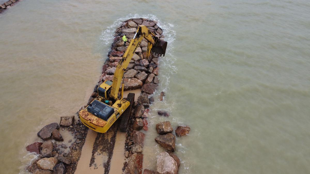 Una maquina trabaja en la construcción de las protecciones del litoral de Almenara.
