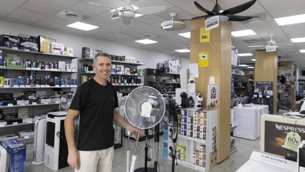 El responsable de Electrodomésticos Miguel con ventiladores de diferentes modelos en la tienda de Alzira.