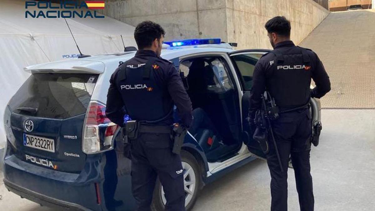 Agentes de Policía junto a un coche.
