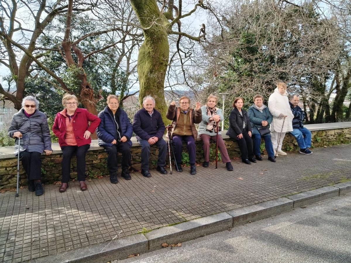 Membros do centro de día descansando durante un paseo.