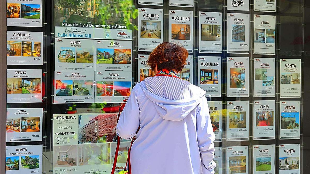 Gente viendo el escaparate de una inmobiliaria.