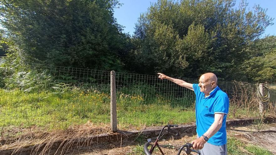 Rufino Meana señala la finca anexa a su domicilio, en Pañeda (Siero), que se encuentra en estado de dejadez. | L. R.