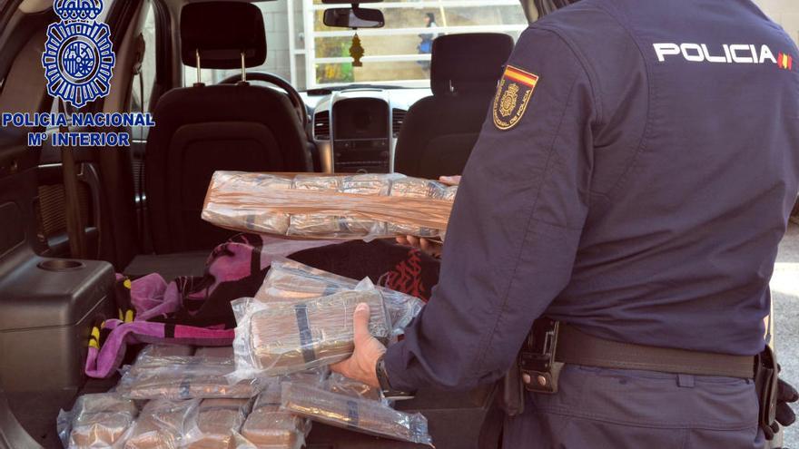 Un agent de la policia estatal inspeccionant la droga.