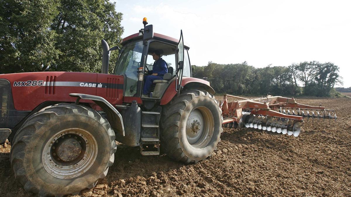 Un tractor treballant en el camp, en una imatge d'arxiu.