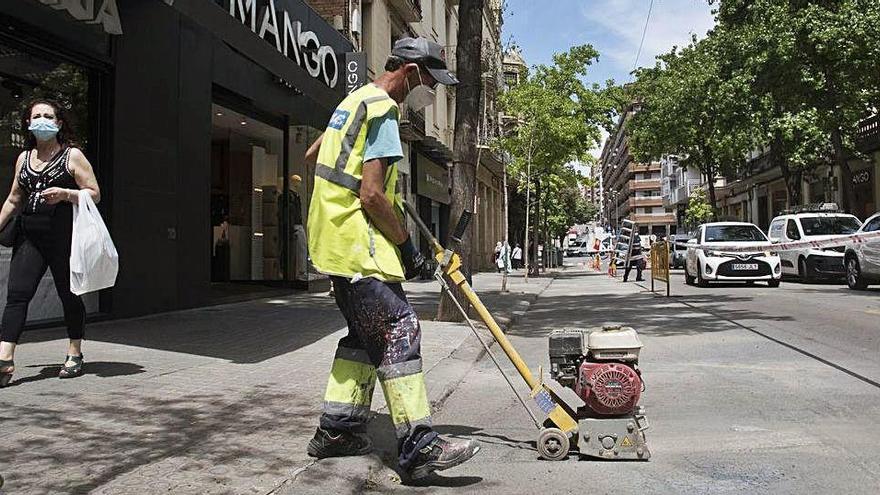 Un operari fressant el terra per esborrar la senyalització horitzontal al carrer d&#039;Àngel Guimerà, ahir