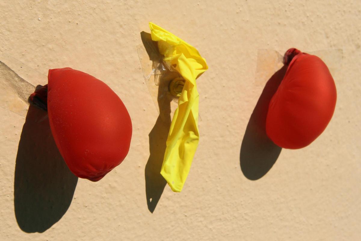 Globos ya deshinchados, junto a otro que ha sido pinchado.