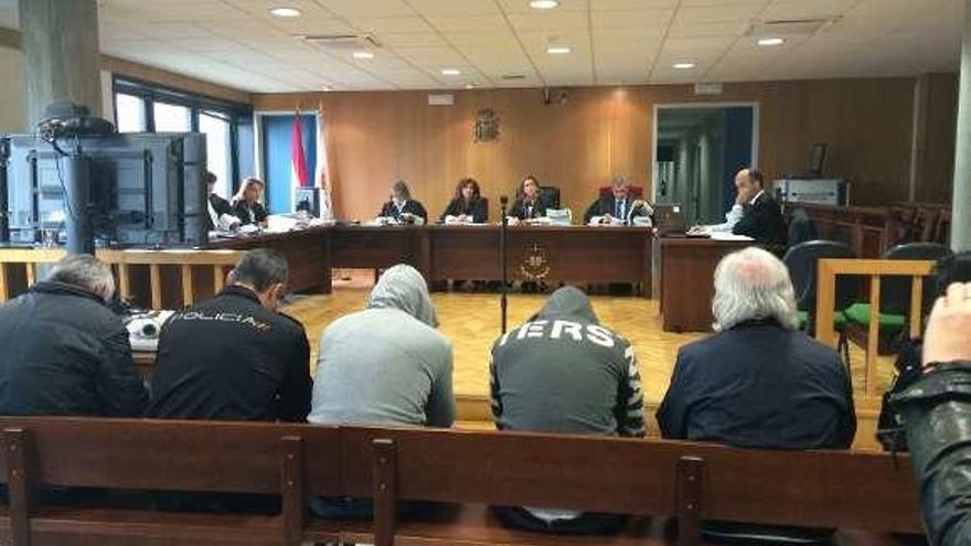 Los cuatro acusados, custodiados por la Policía en el juicio en Vigo.