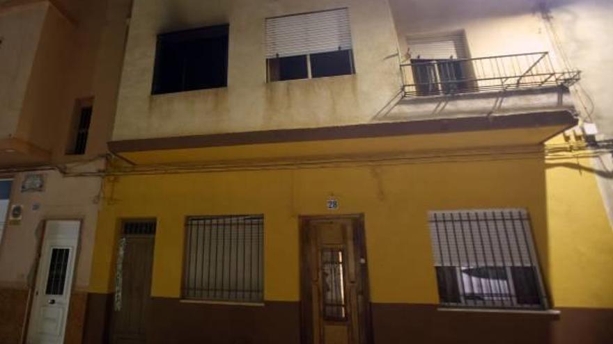 La vivienda afectada y la ventana del primer piso teñida con las marcas del humo.