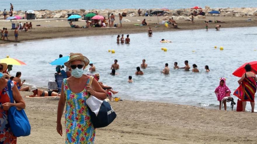 Dos mujeres con mascarillas, en una playa de Málaga capital esta semana.