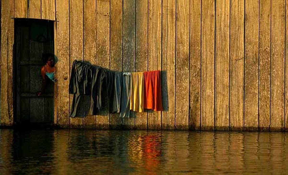Una dona treu el cap a la porta de casa seva inundada al municipi de Riosucio (Colòmbia).