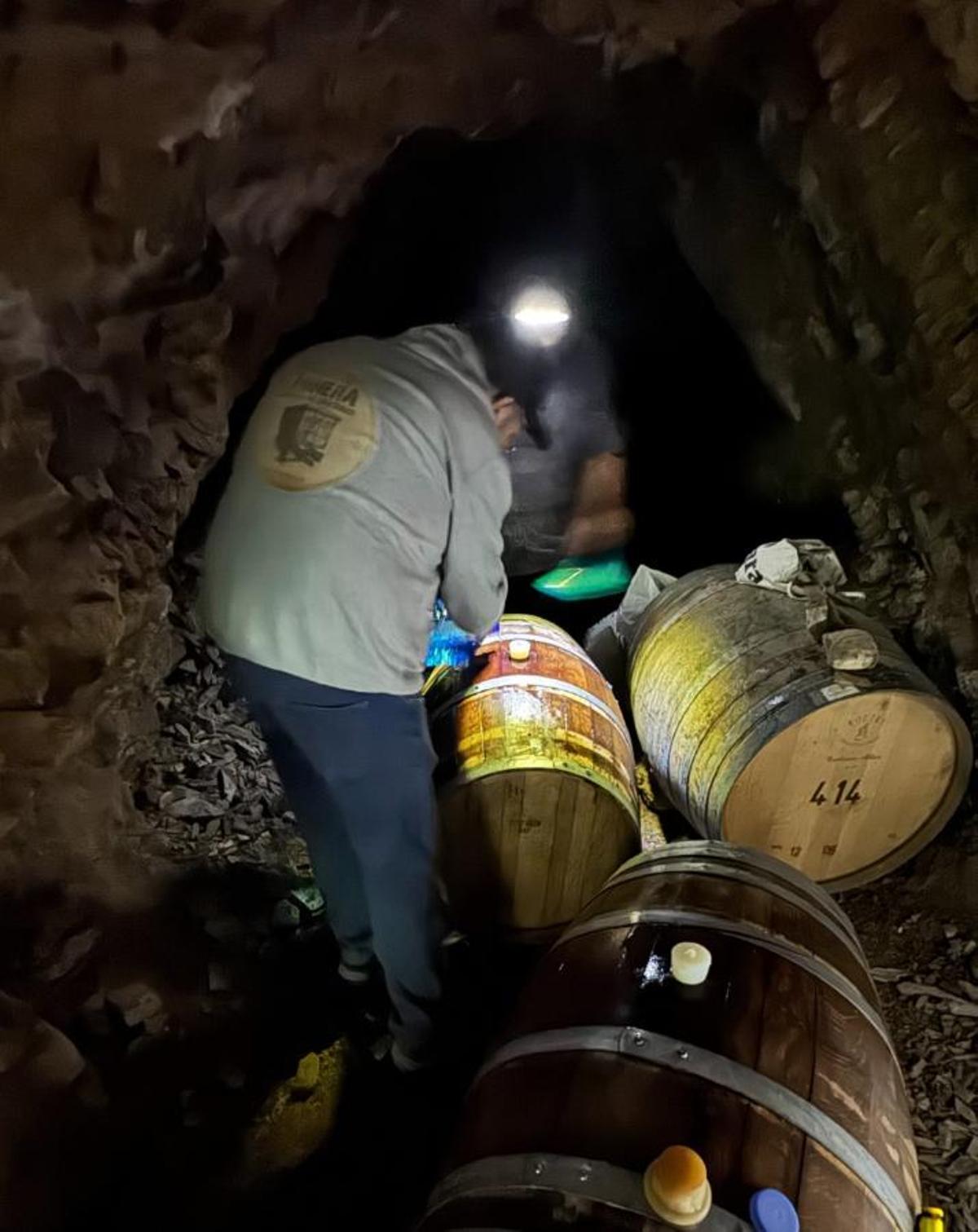 Els dos socis de la marca de cervesa col·locant les botes de cervesa dins la mina.