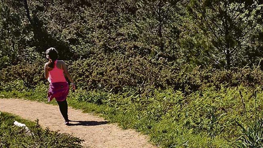 Una mujer realiza deporte en la senda entre Luanco y Bañugues.