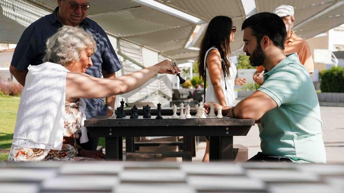 La concejala Teresa Porras juega al ajedrez con el profesor Cristian Claros en el nuevo espacio del parque.