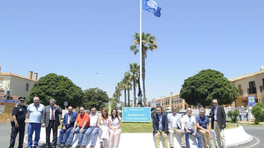 Foto de familia de representantes municipales y empresariales, con la bandera azul de Los Álamos.