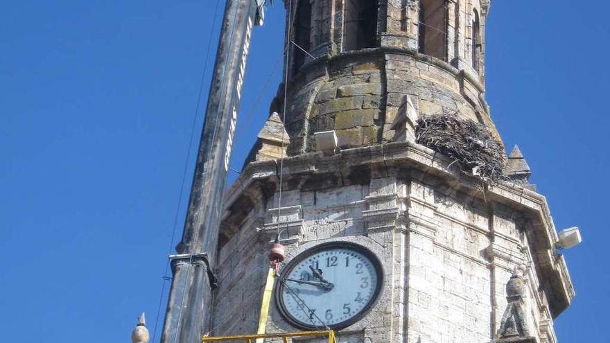 Bomberos de Toro trasladan en una jaula la antigua maquinaria del reloj del monumento.