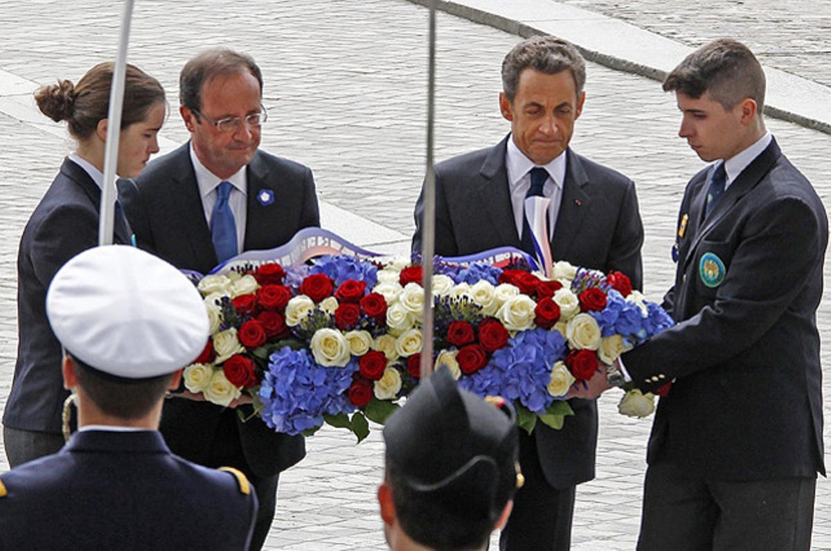 El president sortint, Nicolas Sarkozy, i l’electe, François Hollande, dipositen una corona de flors a la tomba del soldat desconegut, a París, durant una cerimònia per commemorar el final de la segona guerra mundial a Europa.
