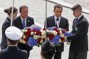 El president sortint, Nicolas Sarkozy, i l’electe, François Hollande, dipositen una corona de flors a la tomba del soldat desconegut, a París, durant una cerimònia per commemorar el final de la segona guerra mundial a Europa.