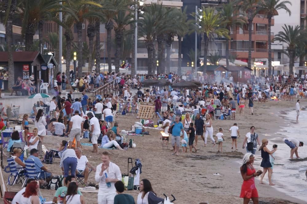 Noche de hogueras, baños, en las playas de la Vega Baja. En las imágenes grupos de amigos y familias en la playa del Cura de Torrevieja