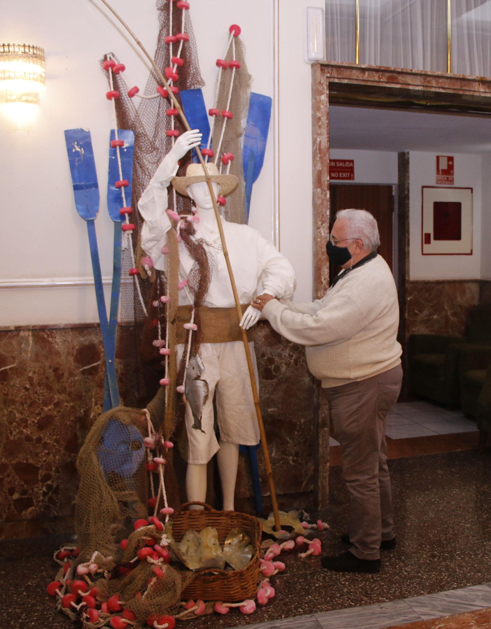 El diseñador Miguel Ángel Castilla coloca el traje de un pescador de época en la muestra de El Recreo.