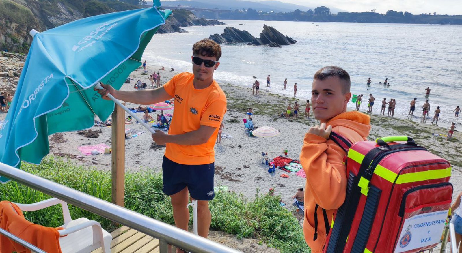 Román López y Nacho del Valle, socorristas en Arnao (Castropol), recogiendo su puesto. | Tania Cascudo 