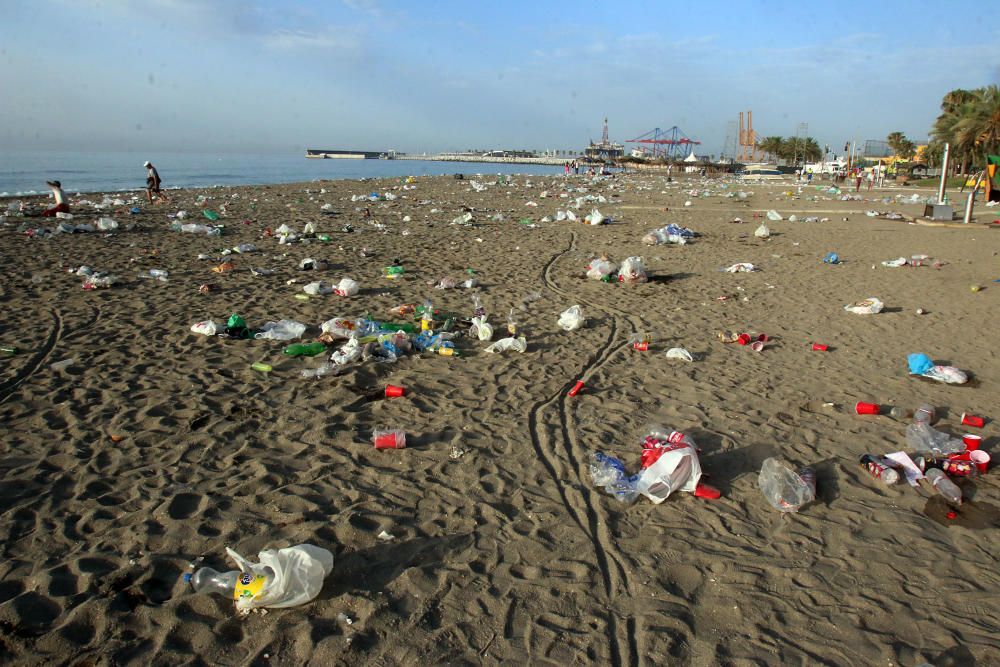 Los operarios de los servicios de limpieza trabajan para dejar la playa en óptimas condiciones tras una larga noche de fiesta en la arena