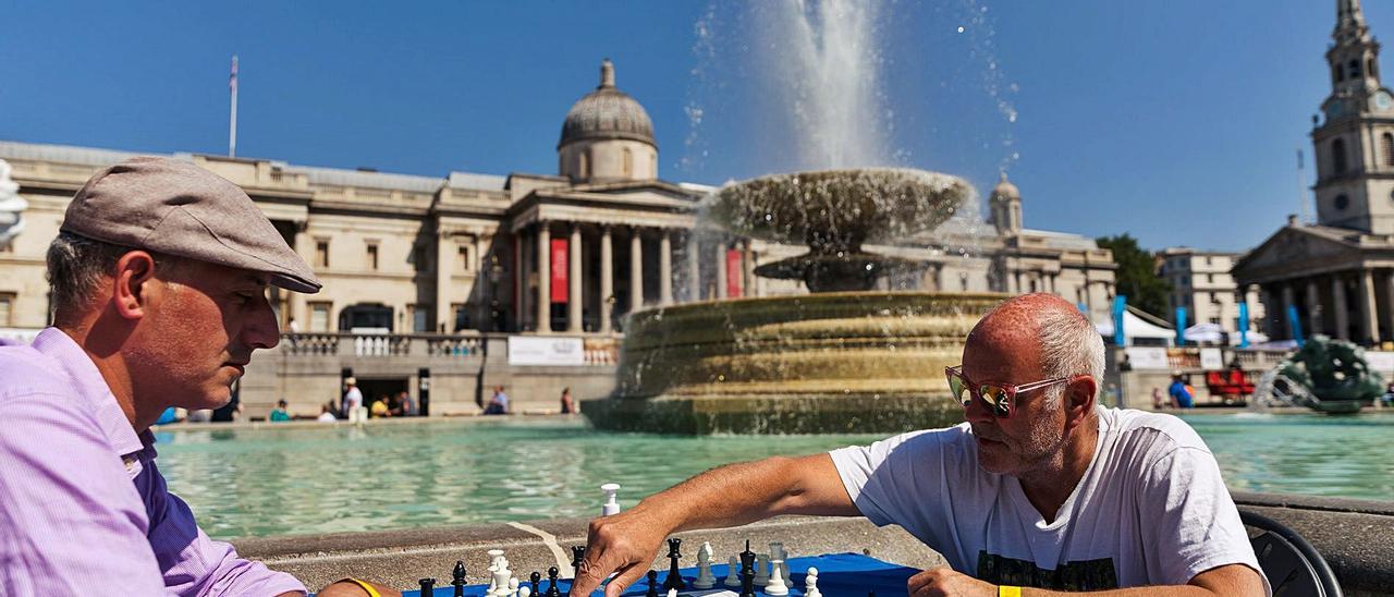 Un jugador mueve ficha durante un festival de ajedrez, ayer en Trafalgar Square, Londres.   | // VICKIE FLORES