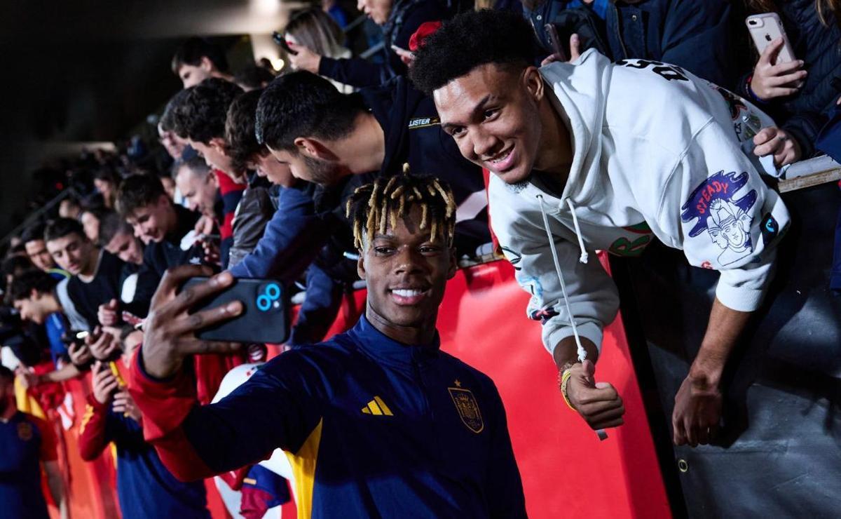 Nico Williams se hace un selfie con un aficionado en la concentración de la selección
