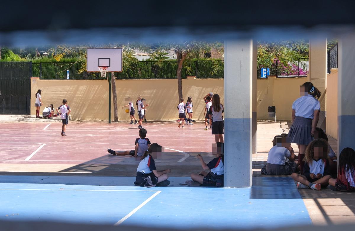 Alumnos resguardándose del sol en un colegio durante el patio, este martes.