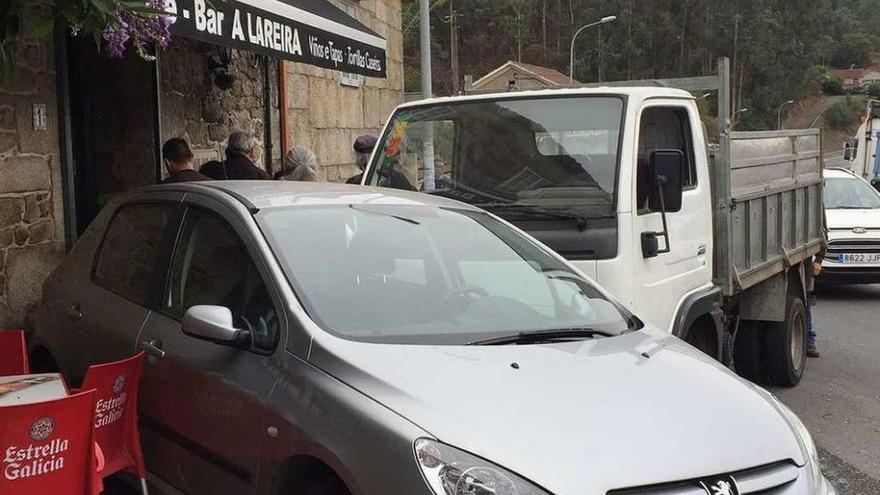 El coche que arrolló a los agentes tras ser embestido por el camión, que está detrás. // R. V.