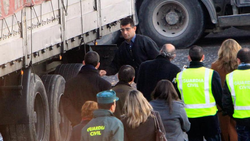 La comisión judicial escucha las explicaciones del acusado junto a las ruedas traseras. A la derecha, a punto de subirse a la cabina.