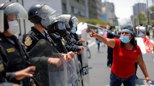 Una mujer, frente a los policías apostados en el Congreso, en Lima, este domingo.