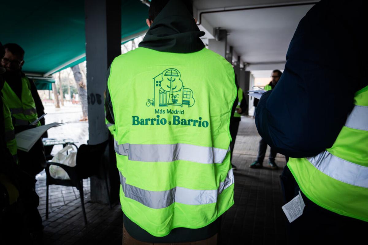 Un militante de Más Madrid con un chaleco rotulado con el mensaje 'Barrio a Barrio'.