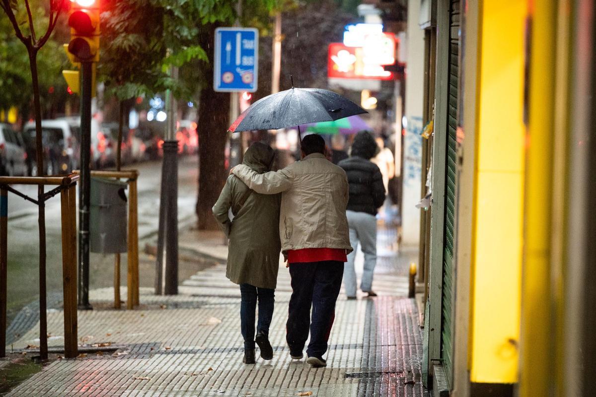 Una pareja se protege de la lluvia con un paraguas en Zaragoza en una imagen de archivo.