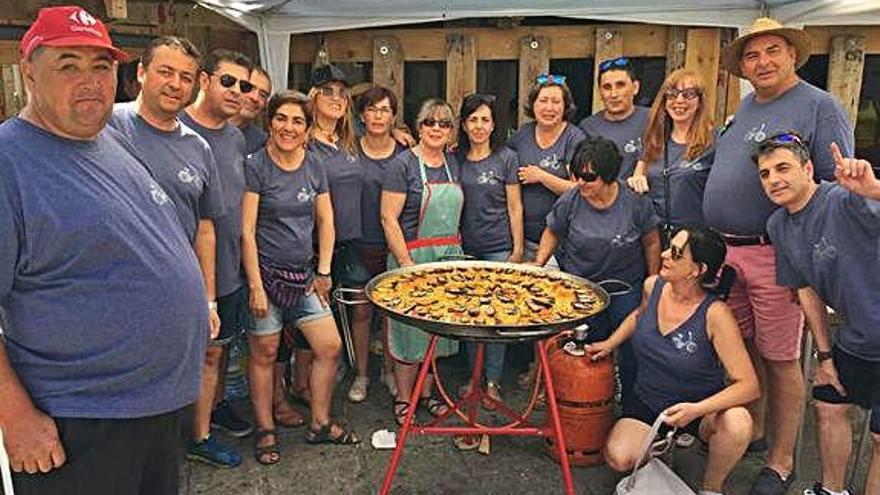 Una peña muestra la paella elaborada en la plaza.