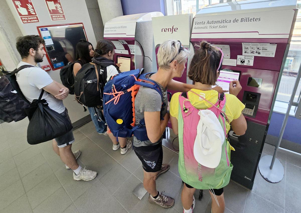 Viajeros de tren ante unas máquinas de autoventa de Renfe en la estación de Vigo-Guixar / Marta G. Brea
