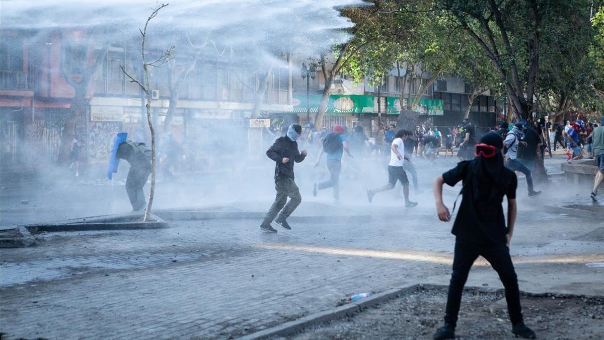 La policía lanza cañones de agua para dispersar a los manifestantes, el pasado sábado en Santiago.