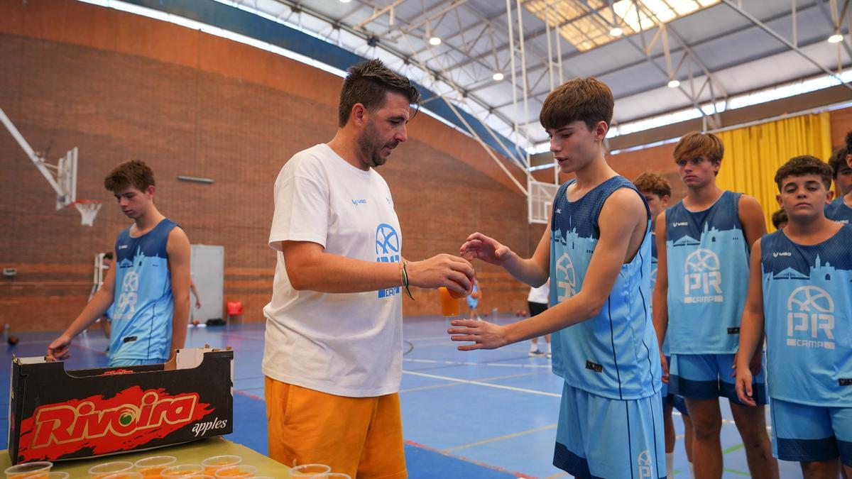 Paco Redondo entrega un zumo de naranja a uno de los participantes en el PR Camp BCB.