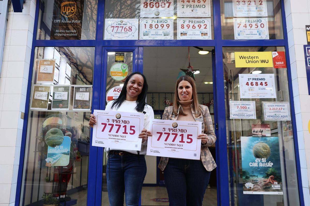 Aylin Torres, a la izquierda, y Patricia Blanco, con el cartel del número agraciado, a la entrada de la administración, en la calle Gran Capitán.