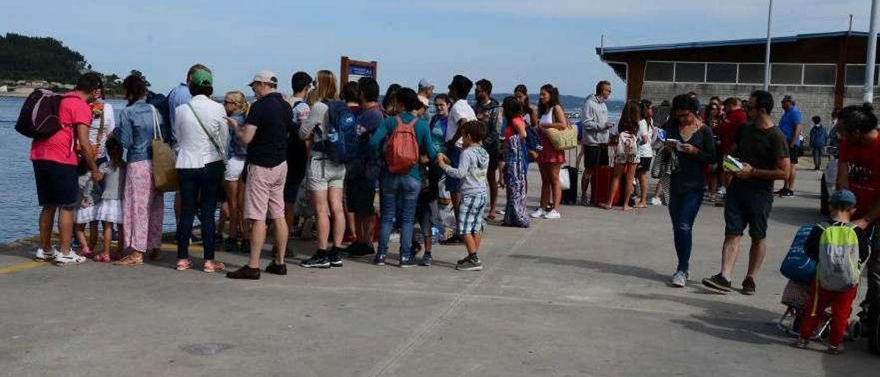 Visitantes, ayer en el puerto de Bueu, esperando para embarcar con rumbo a Ons. // Gonzalo Núñez