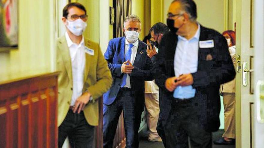 Ángel Víctor Torres, en el centro de la imagen, ayer en los pasillos del Parlamento de Canarias.