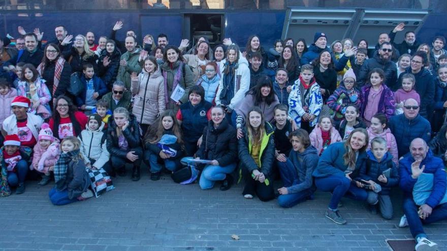 Las familias y los organizadores del viaje junto a los 56 menores que llegaron ayer a València tras tres días de viaje, gracias a la Fundación juntos por la vida.  | LEVANTE-EMV