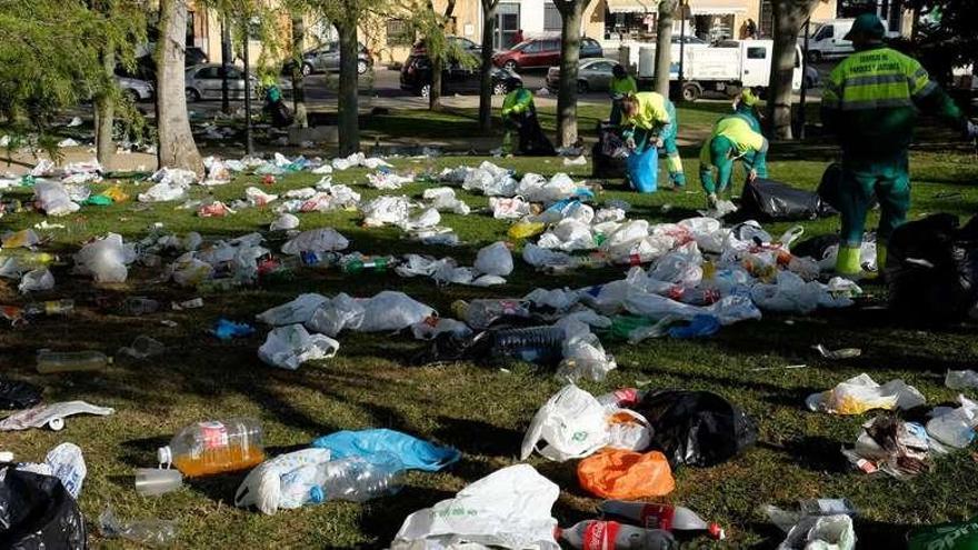 Operarios municipales recogen la basura acumulada tras el macro botellón con el fin de que el parque de San Martín recuperase en cuestión de horas su aspecto original.
