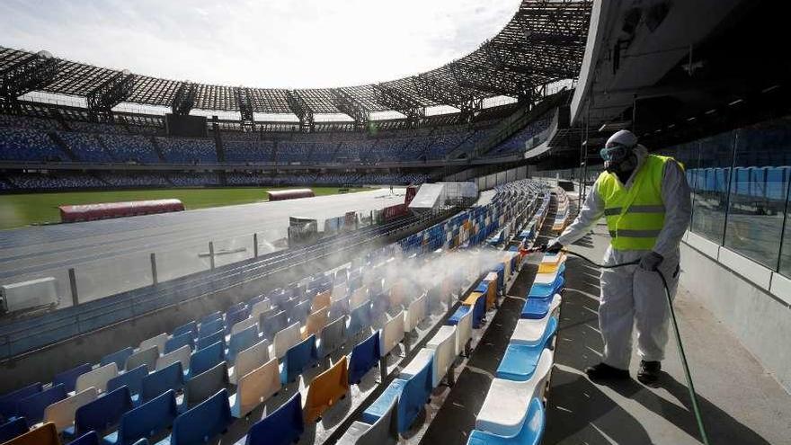 Un operario limpia las gradas del estadio de San Paolo. // Efe