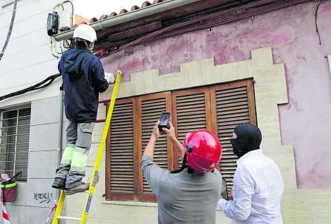 Técnicos revisan un empalme ilegal en una casa donde había un plantación. 