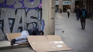 Un hombre duerme en la calle.