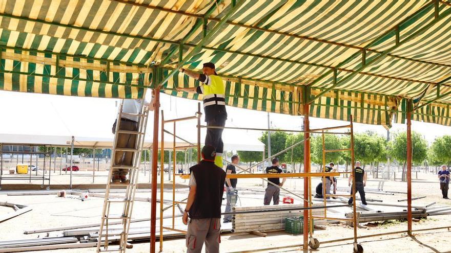 Trabajos de montaje de casetas en el recinto ferial de El Arenal.