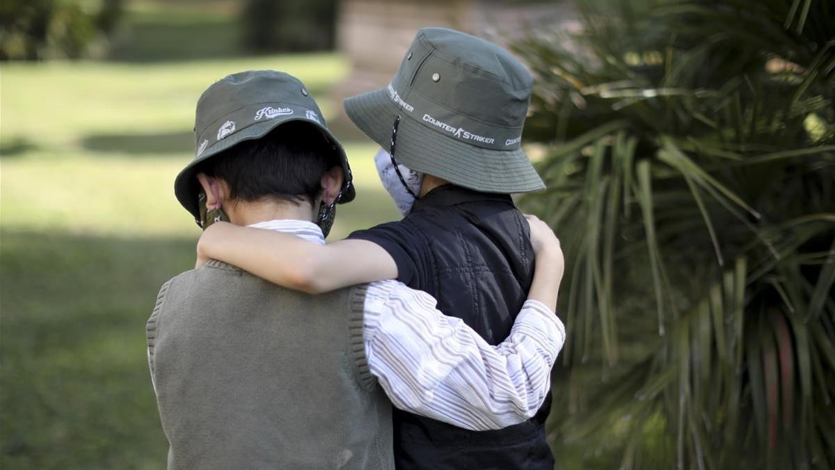 Dos niños con máscarilla, en un parque de Buenos Aires.