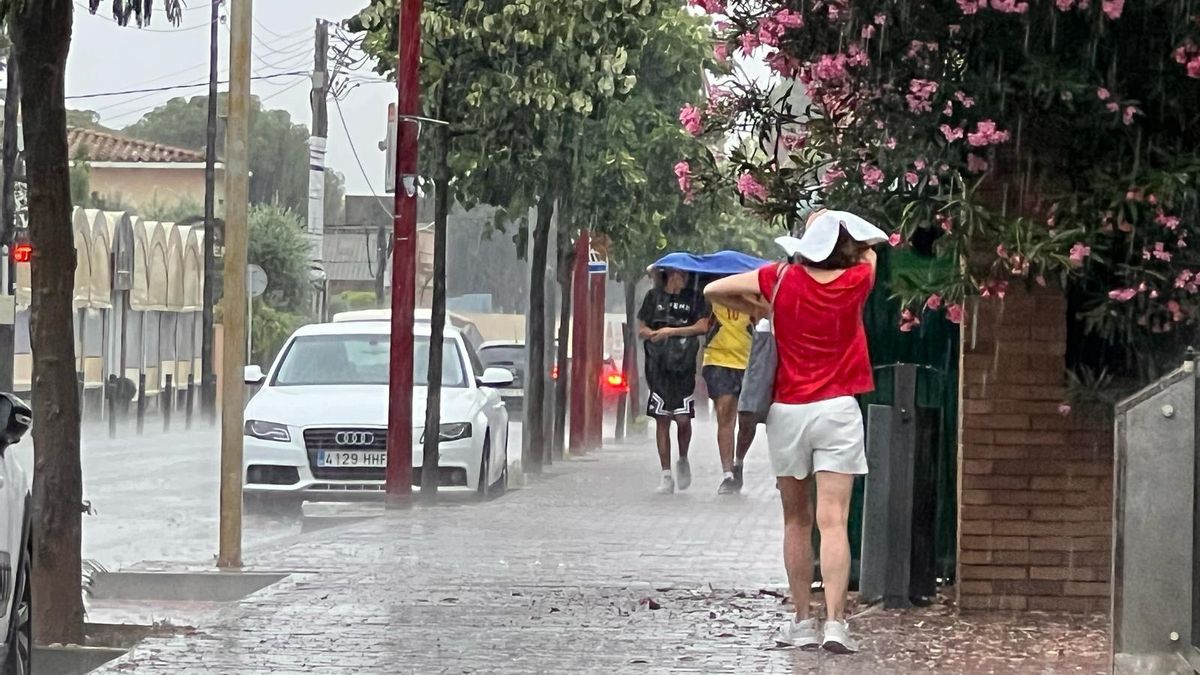 Unos jóvenes tapándose de la lluvia