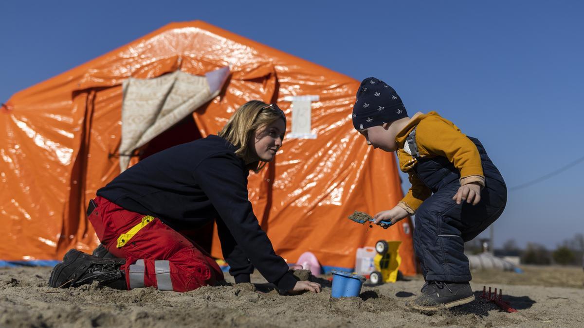 Una voluntaria juega con un niño este lunes en el campamento de refugiados en Budomierz (Polonia).