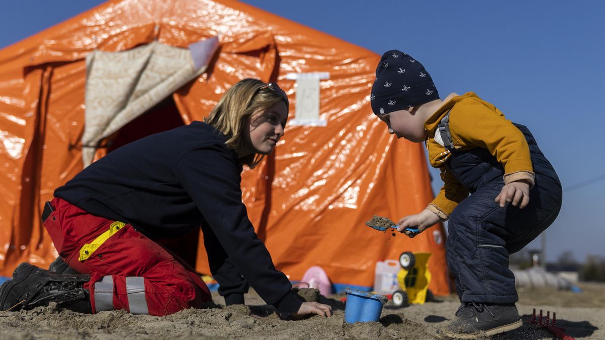 Una voluntaria juega con un niño este lunes en el campamento de refugiados en Budomierz (Polonia).